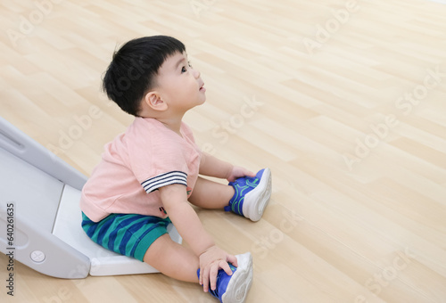 Close up of Asian baby toddler playing kids climber slide in the chidren room. Joyful and healthy child