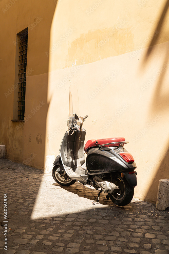 Italian Motor Scooter leans up against the wall of a small roman street
