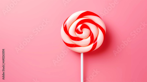 Red and white lollipop isolated on a pink background with editorial space.  