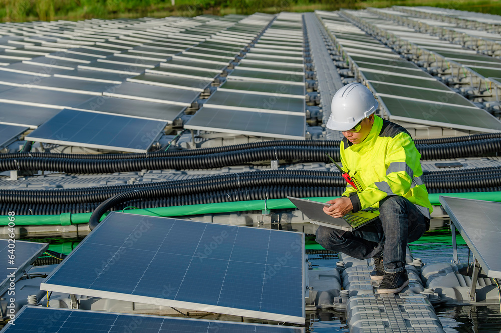 Asian engineer working at Floating solar power plant,Renewable energy,Technician and investor solar panels checking the panels at solar energy installation Asian engineer working at Floating solar power plant,Renewable energy,Technician and investor solar panels checking the panels at solar energy installation
