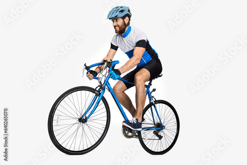 Bearded caucasian cyclist wearing sports equipment, riding bike. Side view of male cyclist making effort to ride fast, isolated on white studio background. Concept of sport lifestyle, action, motion.