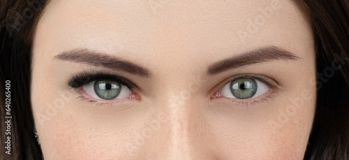 Close up shot of before and after procedure of lash extension. Macro shot of female green eyes with long false volume lashes. Young woman with perfect cat shape eye and beautiful eyelash extensions