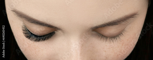 Close up shot of before and after procedure of lash extension. Macro shot of female green eyes with long false volume lashes. Young woman with perfect cat shape eye and beautiful eyelash extensions