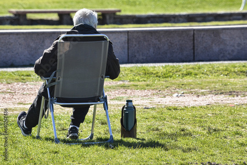 man sitting drinking mate in the park in the late afternoon.