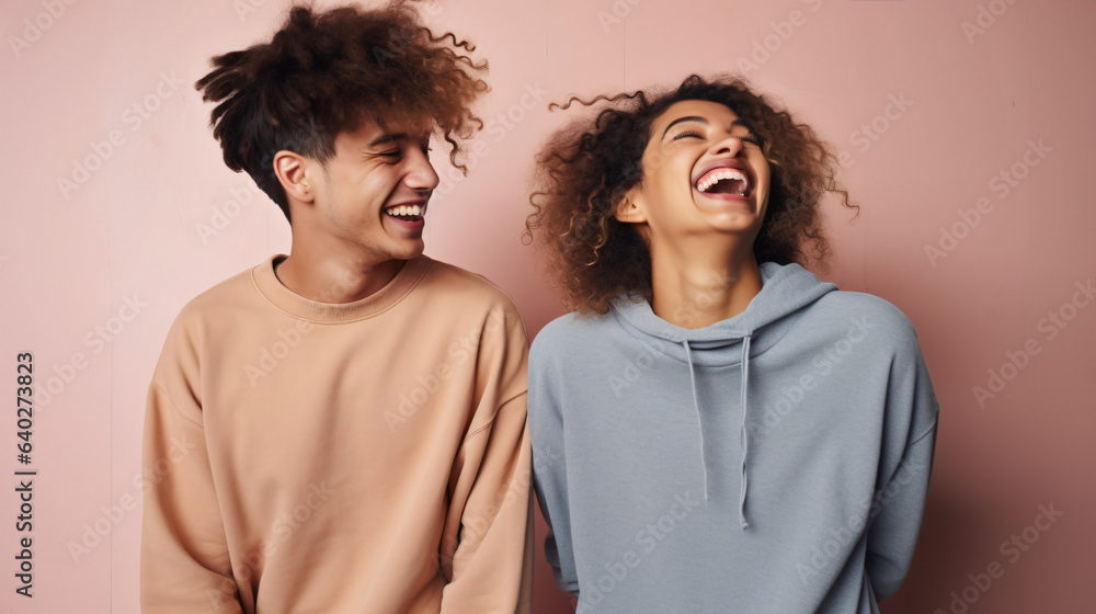 Funny best friends laughing cheerfully while standing together in a studio Funny best friends laughing cheerfully while standing together in a studio