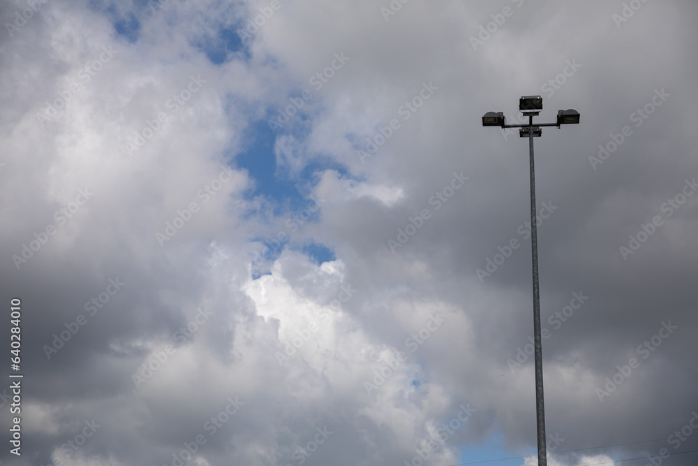 High street lighting lamp against a sky covered with white clouds.