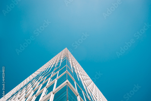 Architecture - skyscraper with plain blue sky and reflections 