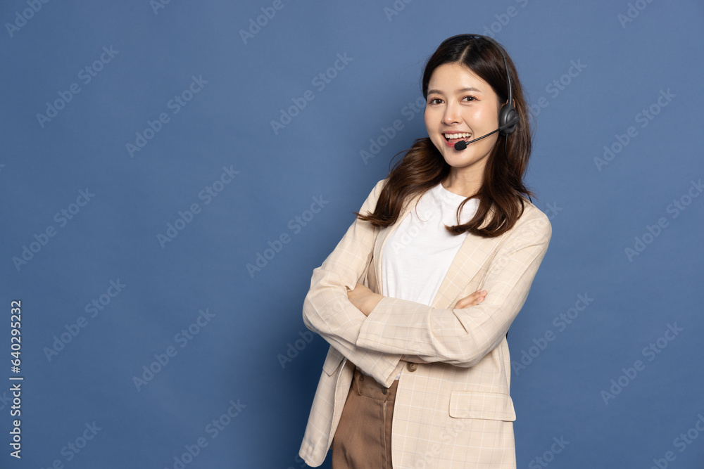 Portrait of happy smiling Asian woman customer operator with headphone isolated on blue background, Call center or Customer service concept Portrait of happy smiling Asian woman customer operator with headphone isolated on blue background, Call center or Customer service concept