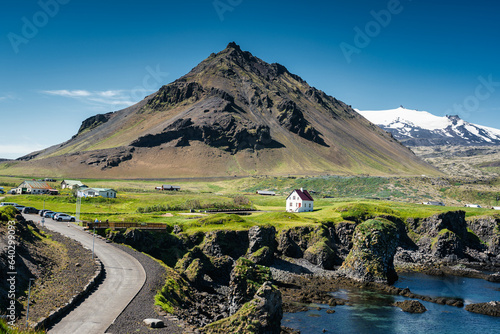 Arnarstapi fishing village with Stapafell mountain and basalt rocks formation on coastline in Snaefellsnes peninsula photo