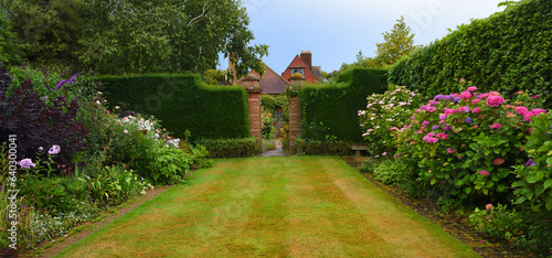 Canvas Print Colourful garden with gate and hedges