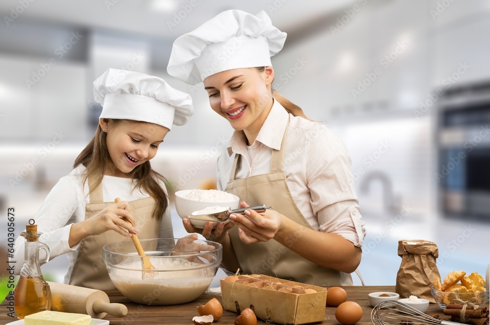 Joyful little child and young mother cooking at home Joyful little child and young mother cooking at home