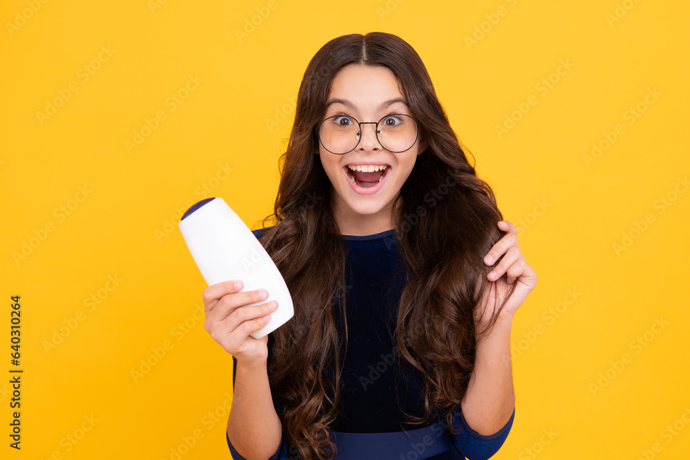 Teenage girl with shampoos conditioners or shower gel. Kids hair care cosmetic product, shampoo bottle. Happy face, positive and smiling emotions of teenager girl. Teenage girl with shampoos conditioners or shower gel. Kids hair care cosmetic product, shampoo bottle. Happy face, positive and smiling emotions of teenager girl.