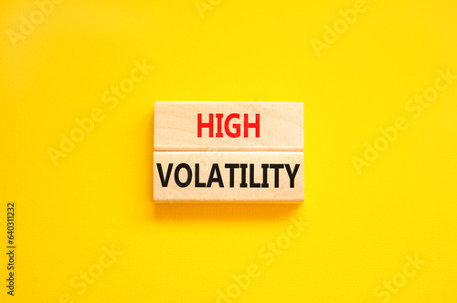 High volatility symbol. Concept words High volatility on beautiful wooden blocks. Beautiful yellow table yellow background. Business high volatility concept. Copy space.