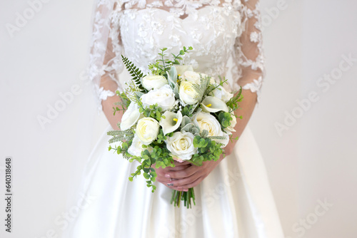 Bride Wedding Dress holding Bouquet white ivory and green flowers floral and ivory dress with detail