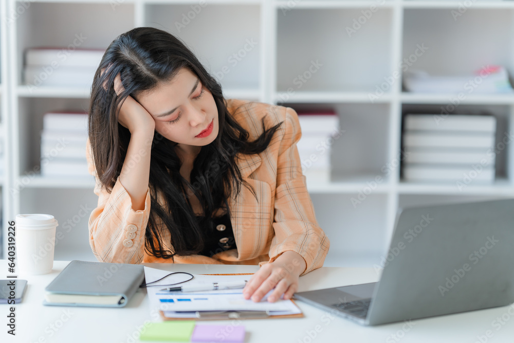 Asian women are stressed while working on laptop, Tired asian businesswoman with headache at office, feeling sick at work, copy space Asian women are stressed while working on laptop, Tired asian businesswoman with headache at office, feeling sick at work, copy space