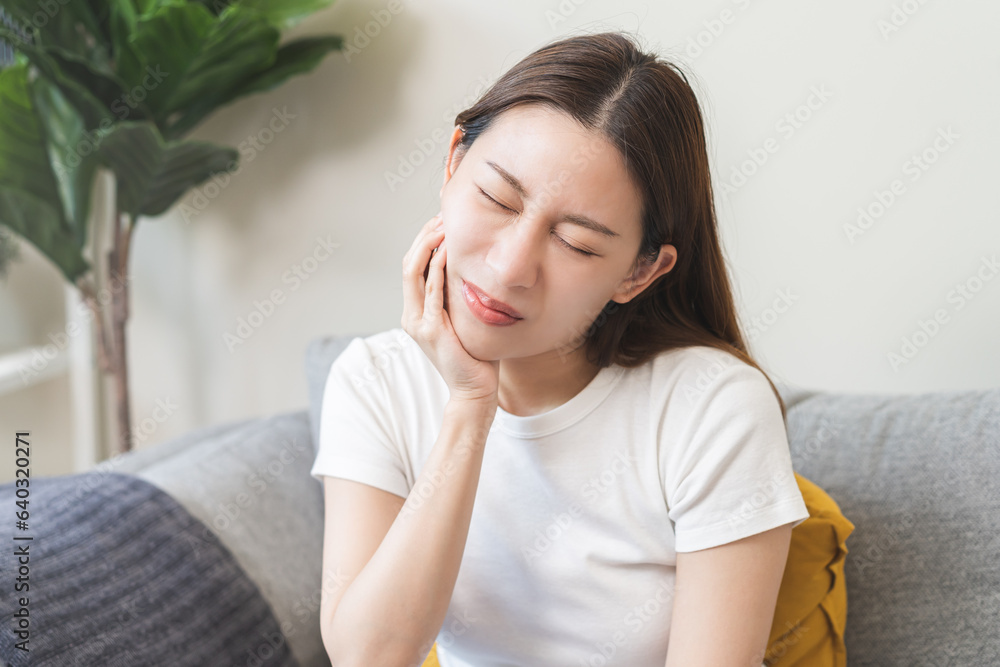 Closing eyes asian young woman hand touching cheek, face expression from toothache, tooth decay or sensitivity, Having tooth or teeth problem or inflammation, suffering from health. Sensitive teeth. Closing eyes asian young woman hand touching cheek, face expression from toothache, tooth decay or sensitivity, Having tooth or teeth problem or inflammation, suffering from health. Sensitive teeth.