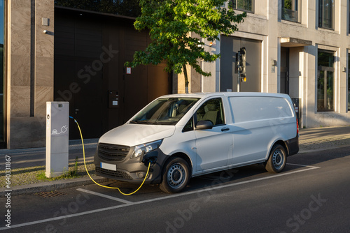 charging electric white delivery van in the city