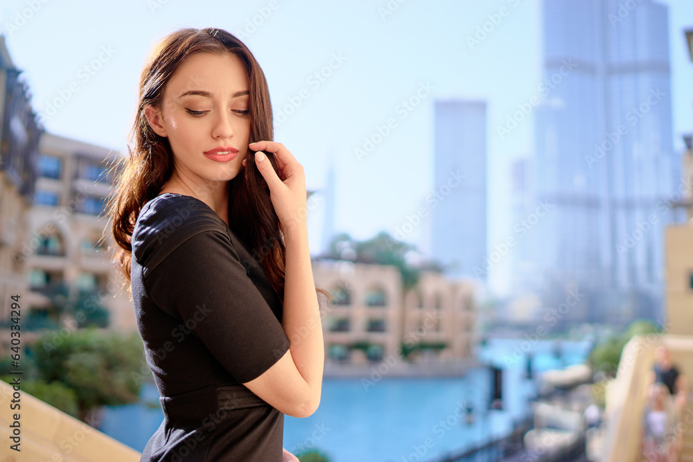 Close-up portrait of beautiful caucasian woman with charming smile and long hair walking on the city streets.