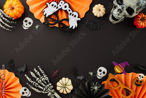 Spooky elements for Halloween theme. Top view photo of paper fans, ghostly eyewear, skull, spooky skeleton hands, pumpkins, scary insects on black background with promo spot