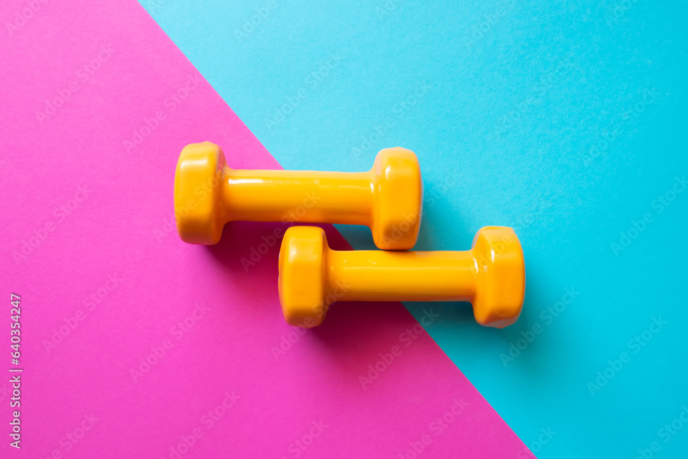 Two dumbbells for sport on the pink blue background. Two dumbbells for sport on the pink blue background.