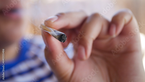 Close-up of a person smoking a joint blurred face