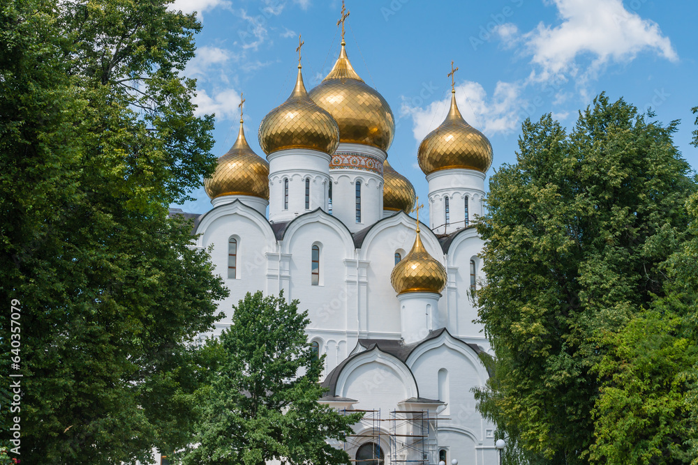 Yaroslavl, Russia, July 4, 2023. The golden domes of the Assumption Cathedral among the trees of the park.