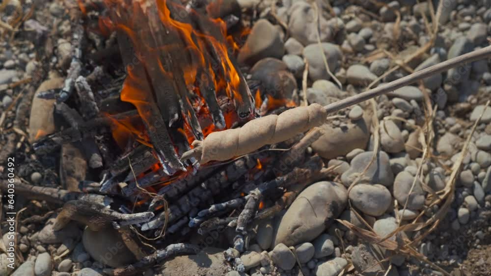 Baking twisted bread, called Stockbrot or Schlangenbrot in German, over a fire on a sunny afternoon by river. Favorite outdoor barbecue in Switzerland and Germany at any time of year. Healthy snack. 