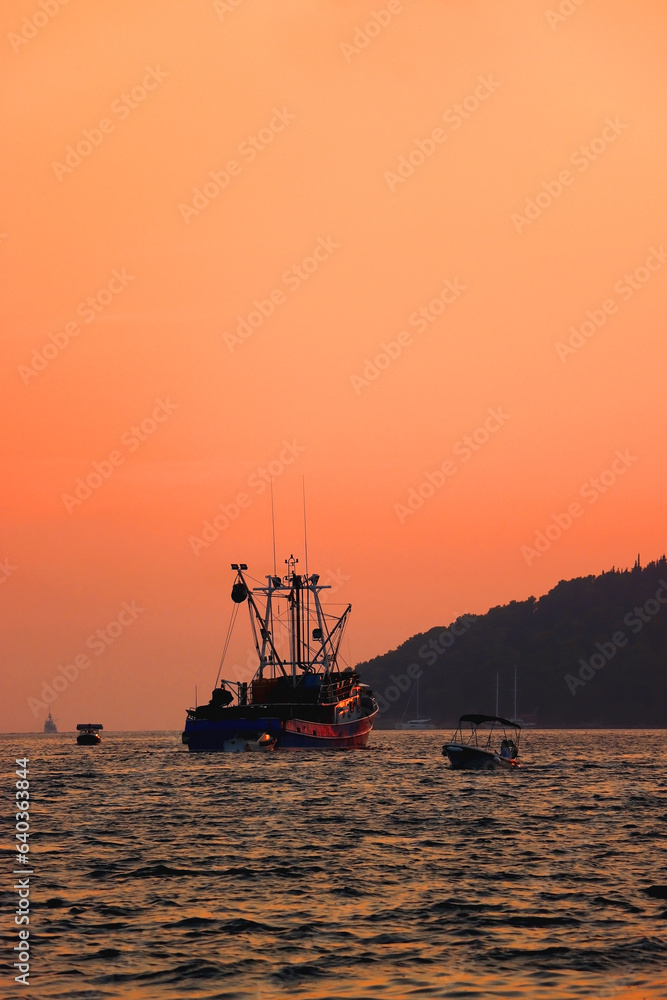 Fishing boat sailing at sunset, in Vela Luka, island Korcula, Croatia. 