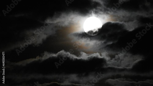 clouds moving slowly in front of full moon