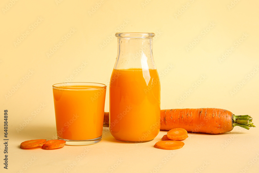 Bottle and glass of fresh carrot juice on orange background Bottle and glass of fresh carrot juice on orange background