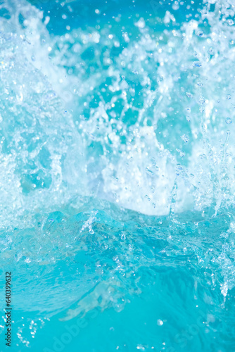 Blue Pool or hot tub water background close up. Ripples on blue transparent water in swimming pool with light reflection. Top view. Summer vertical banner