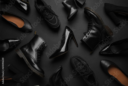 Different stylish shoes on black background