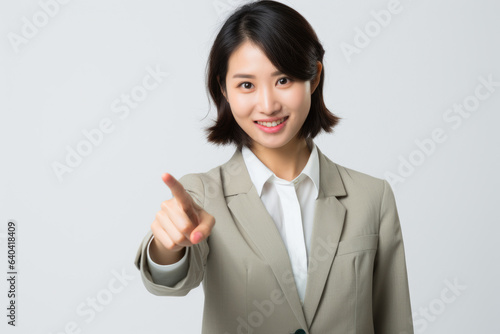 Professional woman in business suit giving thumbs up gesture. This image can be used to represent success, approval, positivity, or business achievements.