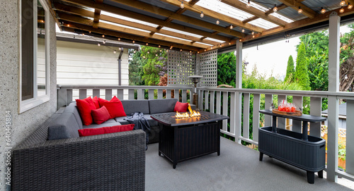 red deck patio with fire-pit, Designer second floor outdoor back patio porch with a sectional couch and red accents 
