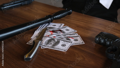 bloody knife, gun and money on the table. knife, gun, blood and american dollars. 