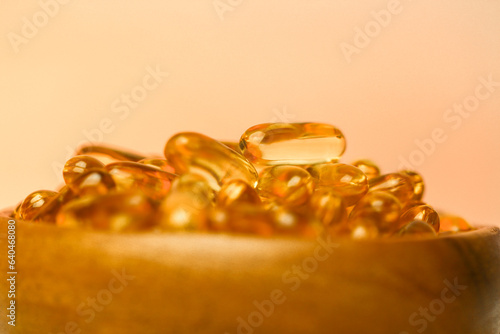 Fish oil capsules in a wooden cup .Omega fatty acids in jelly capsules.Dietary supplements and vitamins in nutrition.