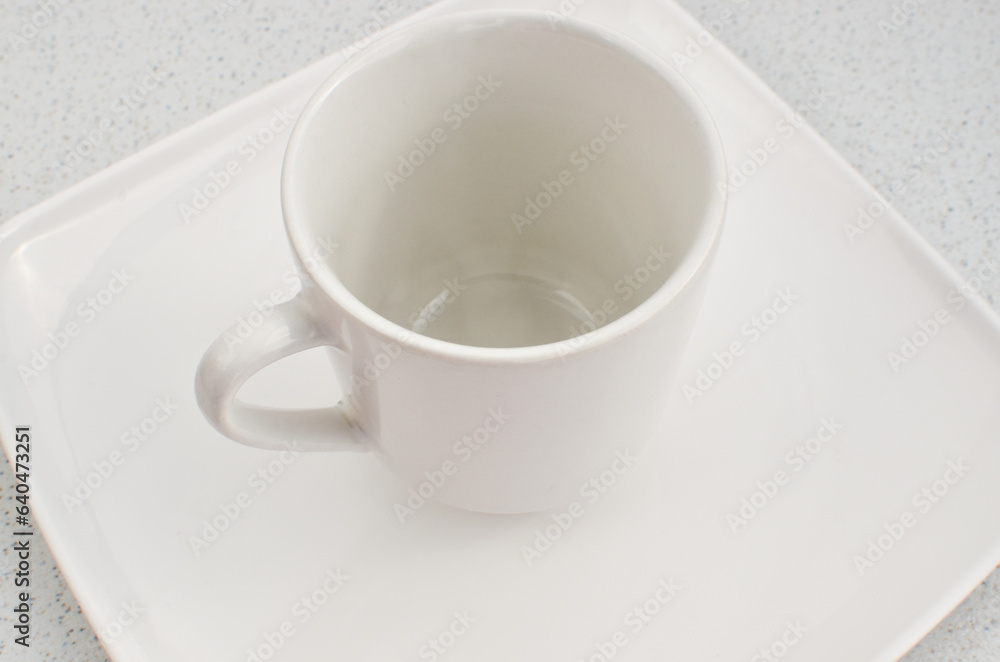 Closeup of an empty high quality china cup on a white plate, a perfect match. Closeup of an empty high quality china cup on a white plate, a perfect match.