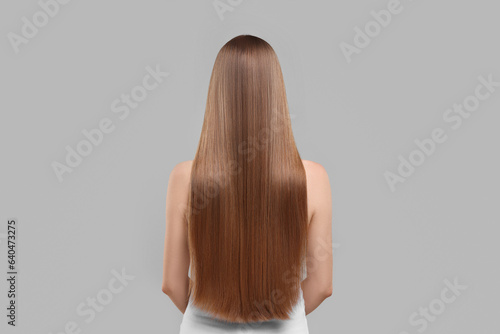 Woman with healthy hair on light grey background, back view