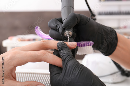 Professional manicurist working with client in salon  closeup