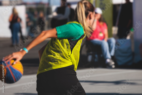 Female athletes play basketball, teenage team play street basketball, players on the outdoor basketball court venue, sports team during the game, playing match game in a summer sunny day