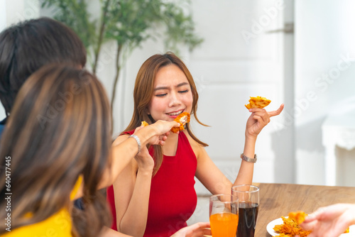Canvas Print Group of Young Asian man and woman friends having dinner party eating food and drinking soft drink together at home