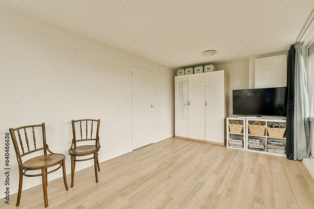 Fototapeta premium a living room with two chairs and a flat screen tv on the wall in the corner of the room is white