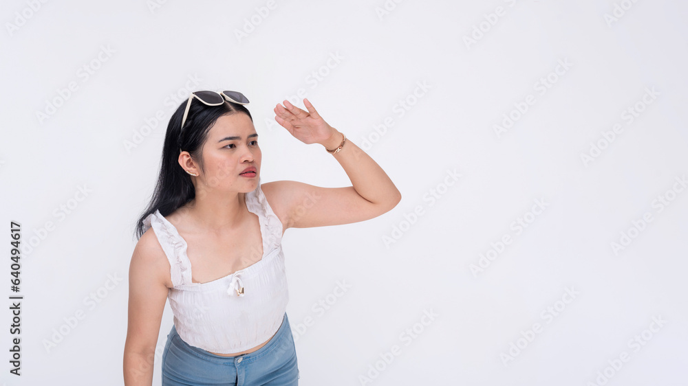 A curious young lady notices something from afar from her right. Trying to get a better view. Copyspace on right. Isolated on a white backdrop. A curious young lady notices something from afar from her right. Trying to get a better view. Copyspace on right. Isolated on a white backdrop.