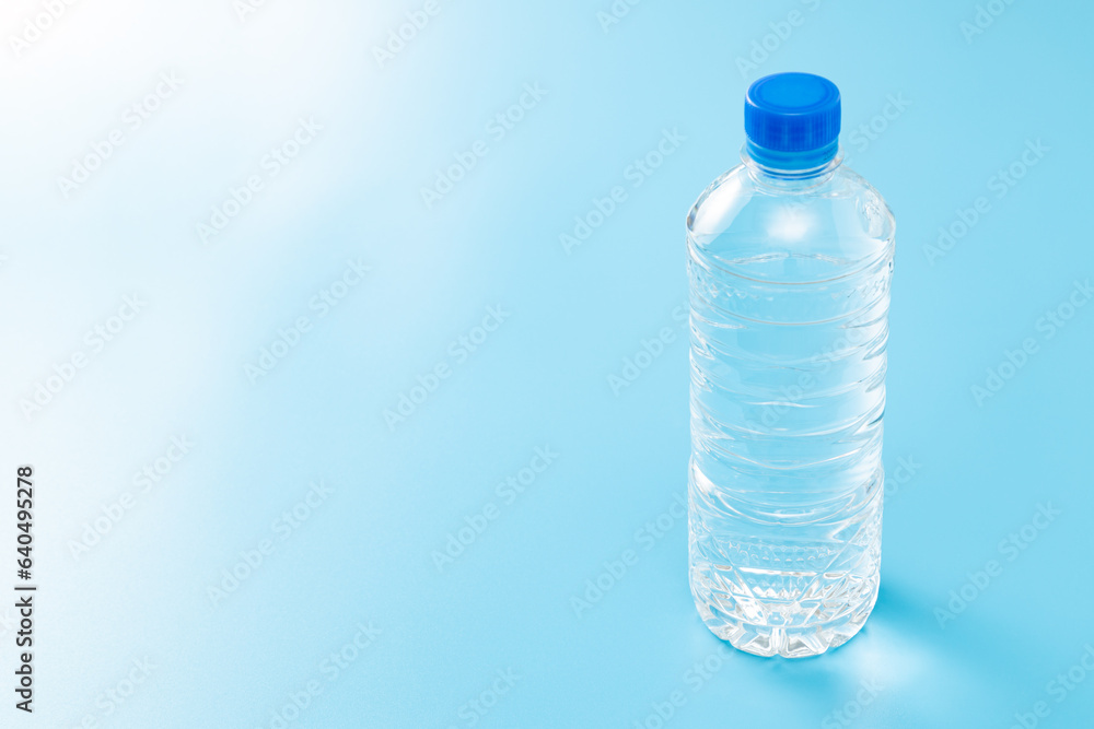 Naklejka premium 青背景にペットボトルの水