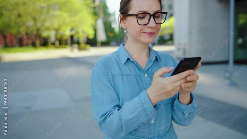 Caucasian woman in glasses walking around the city and using smartphone Caucasian woman in glasses walking around the city and using smartphone