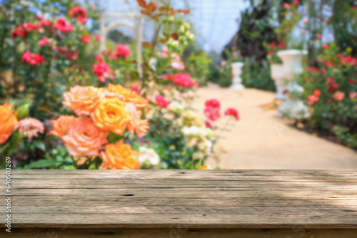 Empty wood table top with blur rose garden background for product display