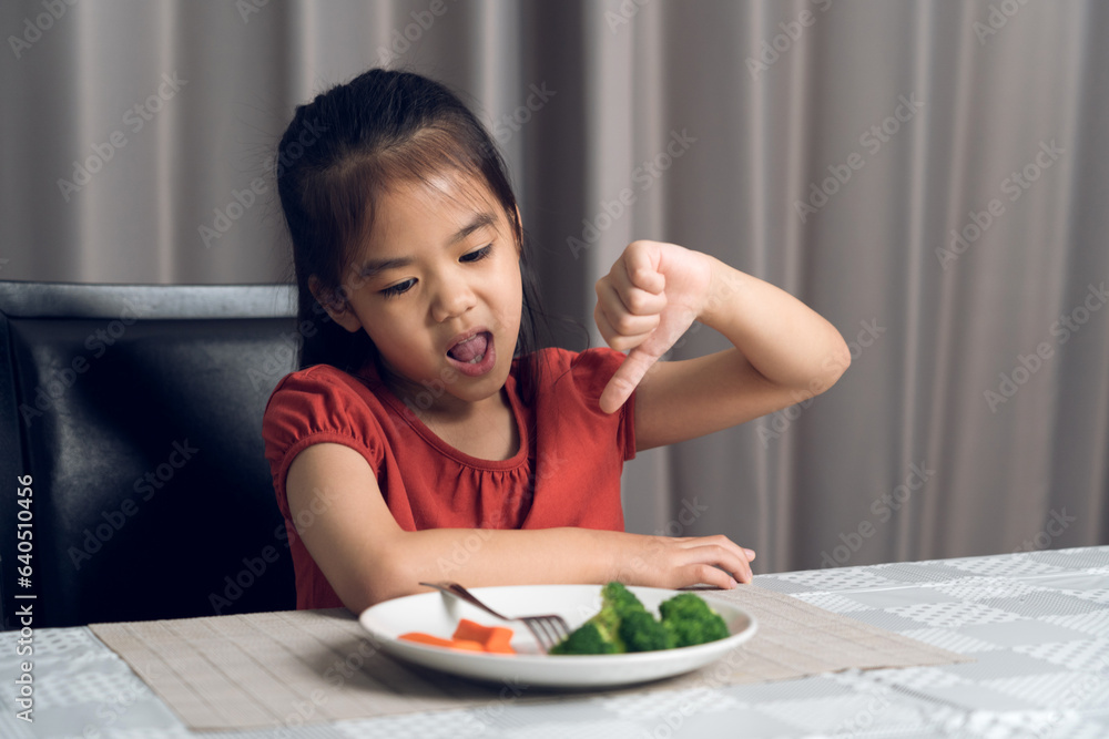 Little cute kid girl refusing to eat healthy vegetables. Children do not like to eat vegetables. Little cute kid girl refusing to eat healthy vegetables. Children do not like to eat vegetables.
