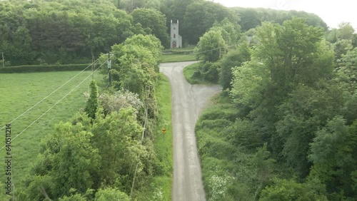 Road Along The Green Trees And Meadow Towards The Curraclone Church In Stradbally, Laois, Ireland. - aerial photo