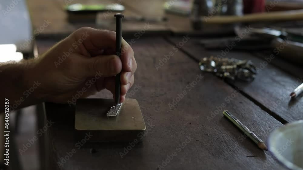 Jeweler hand shaping and designing a silver ring, close up Jeweler hand shaping and designing a silver ring, close up