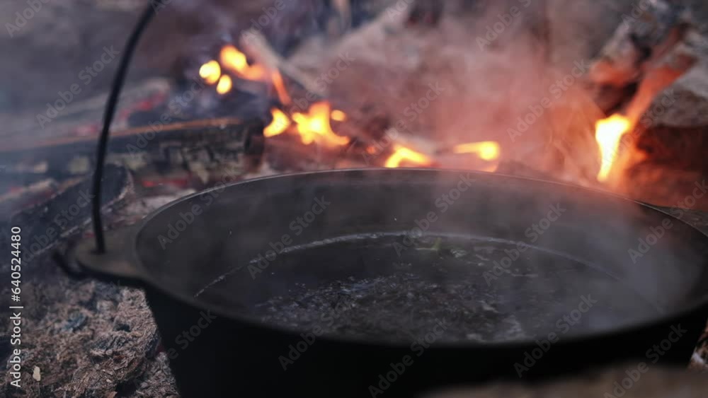 A camping cauldron in which soup is cooked on fire. Tourism in nature. Fire at the stake. A camping cauldron in which soup is cooked on fire. Tourism in nature. Fire at the stake.